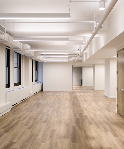 Empty white office floor with wood flooring and arched windows
