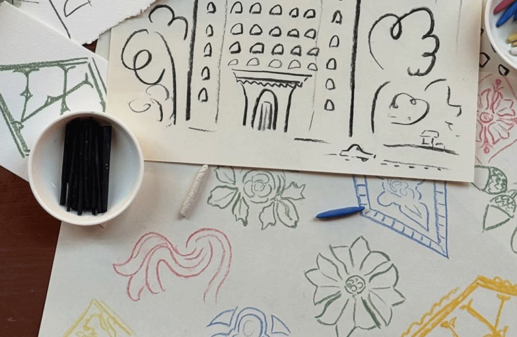Woolworth Building drawings arranged beside coffee and art supplies