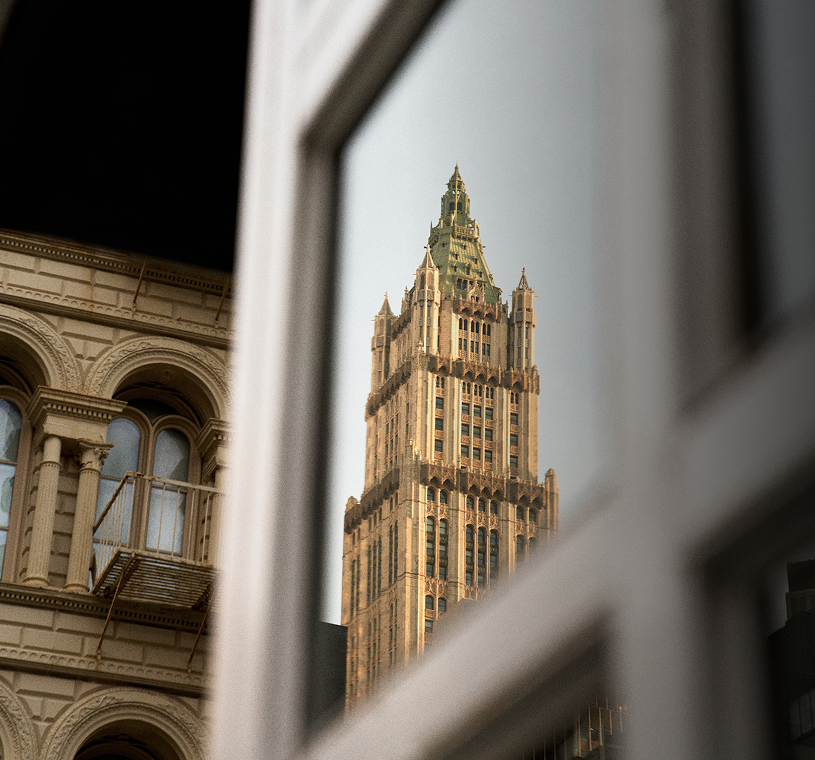 Woolworth Building tower framed between neighboring facades