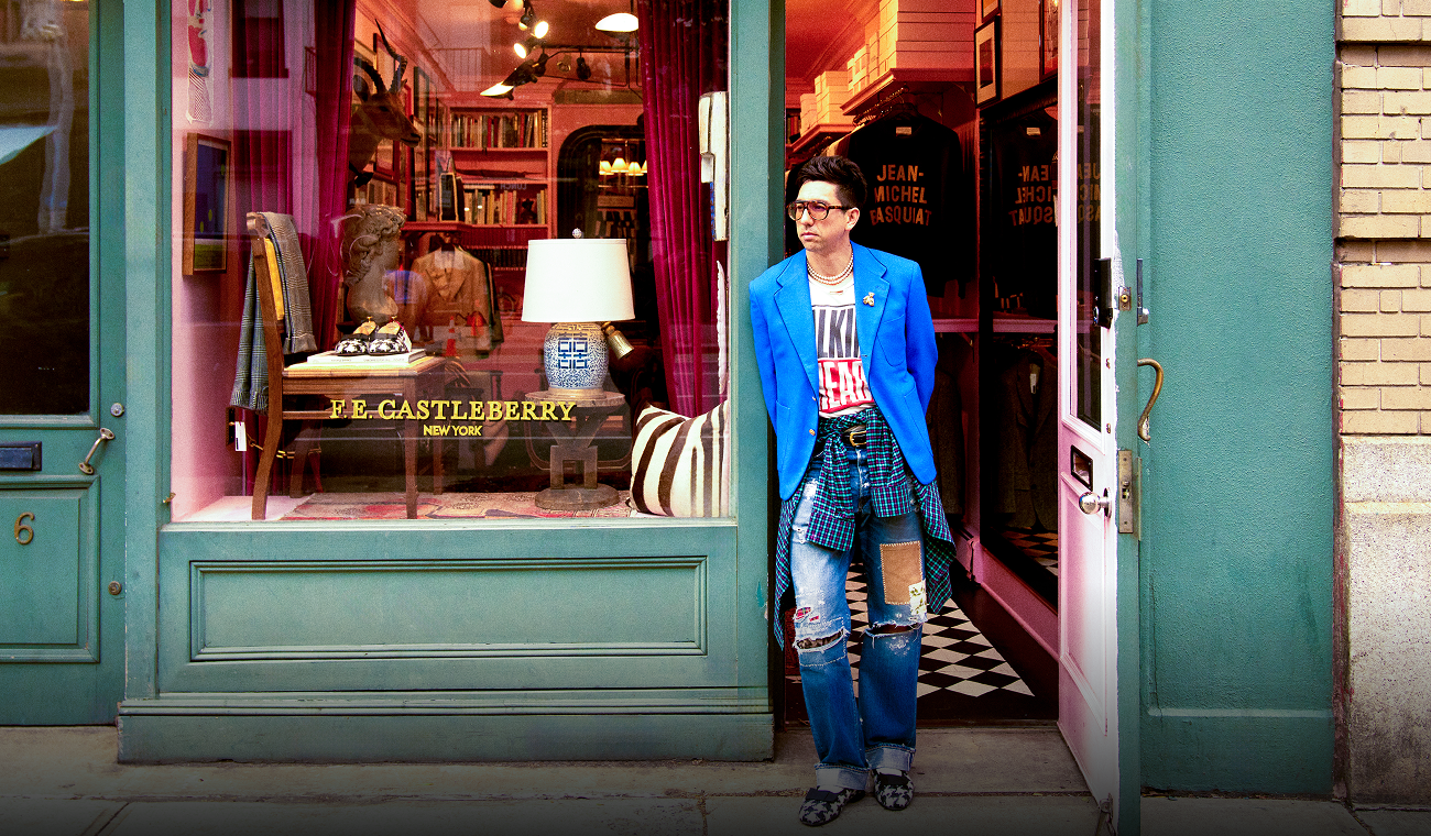 Person standing outside a colorful neighborhood storefront