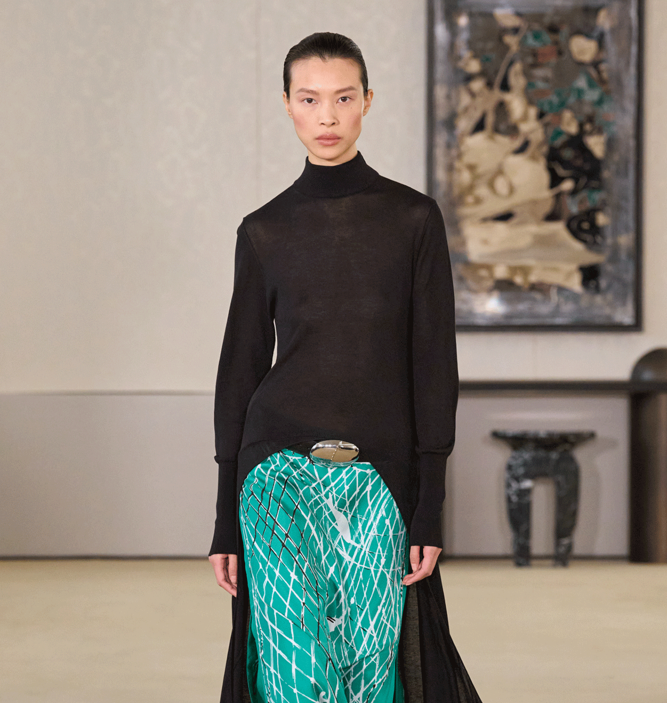 Model in a black top and turquoise skirt walks the Altuzarra runway
