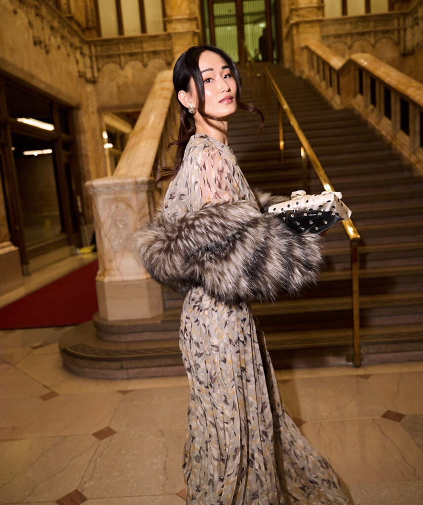 Woman in a feathered dress descends the Woolworth Building staircase