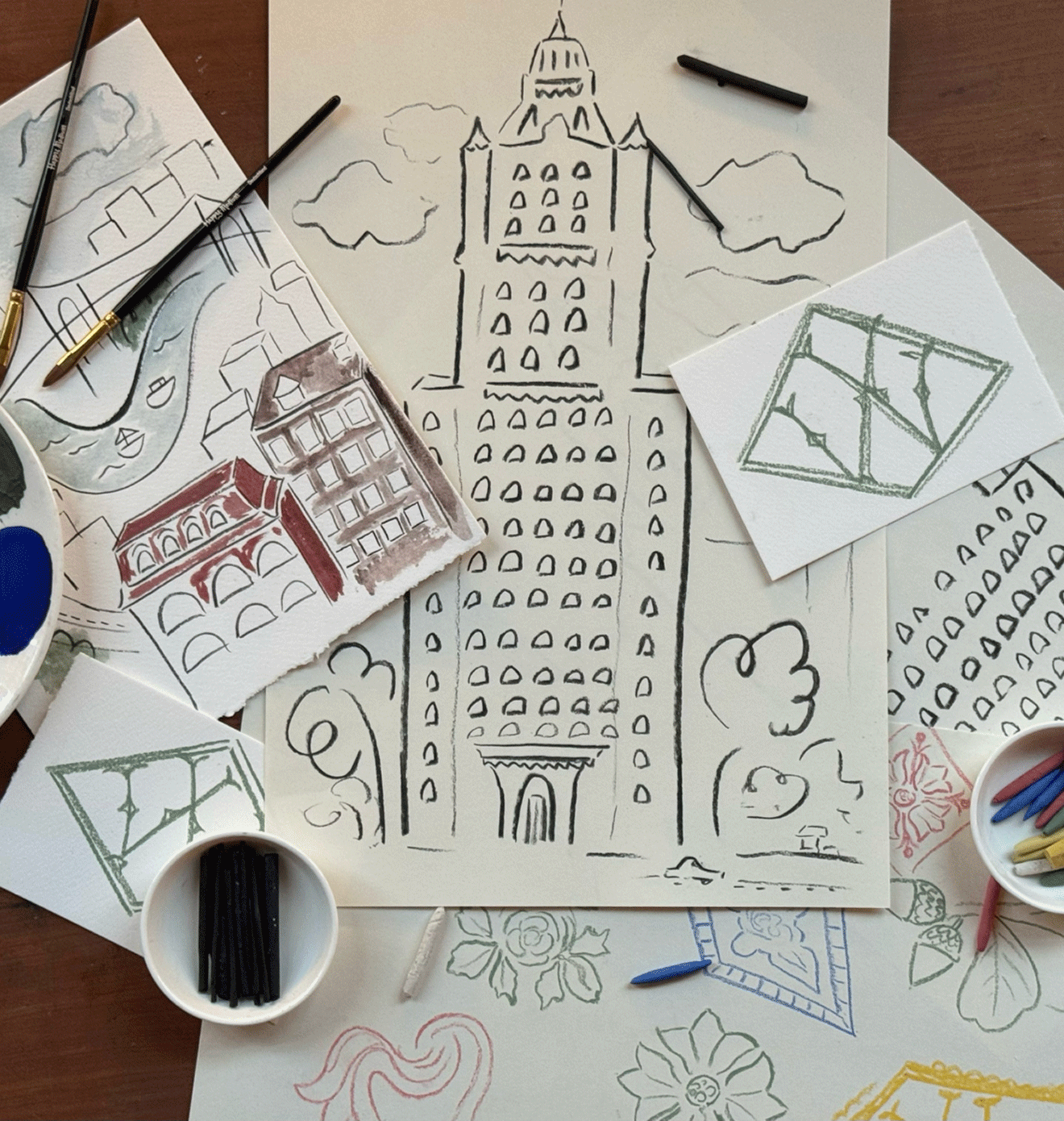 Drawings of the Woolworth Building beside art supplies and coffee