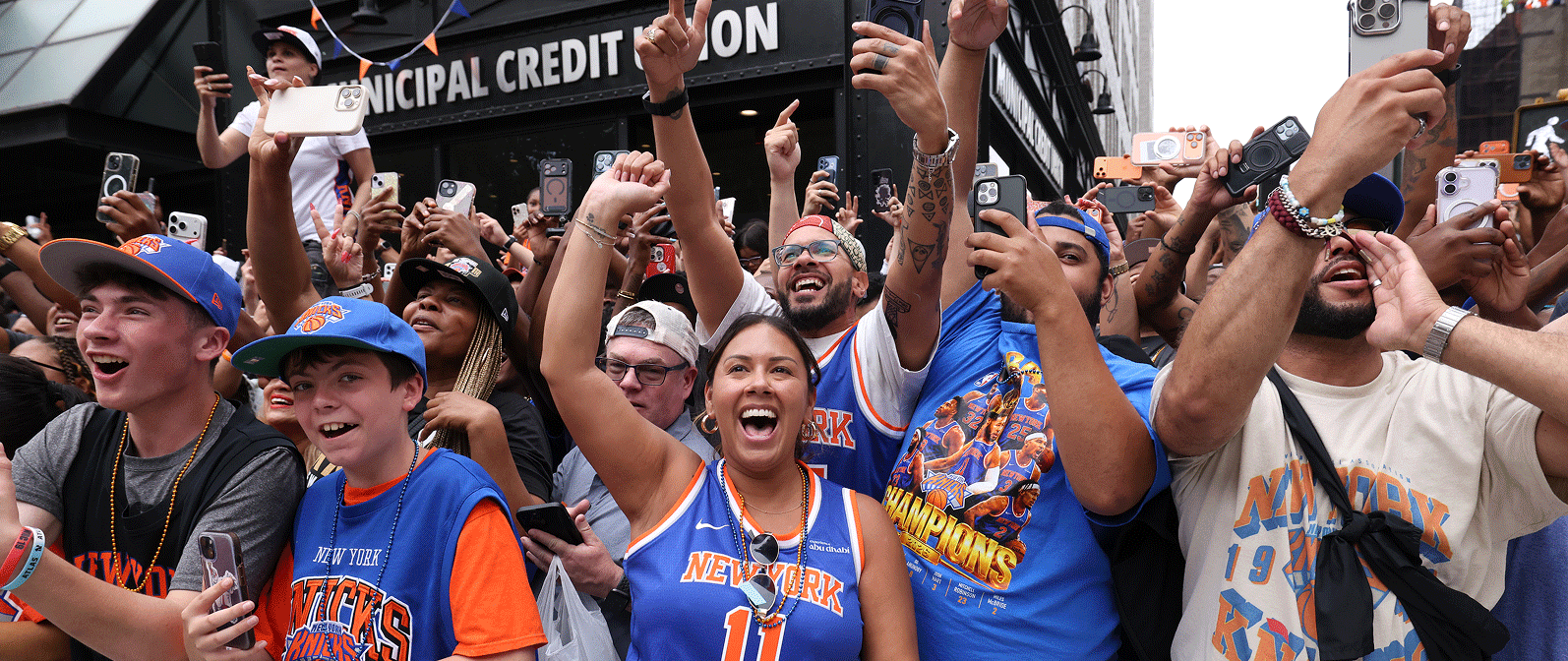 Knicks fans cheer behind a parade barricade