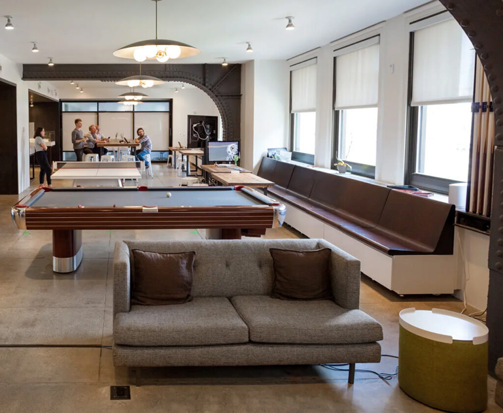 Open office lounge with a pool table and city views