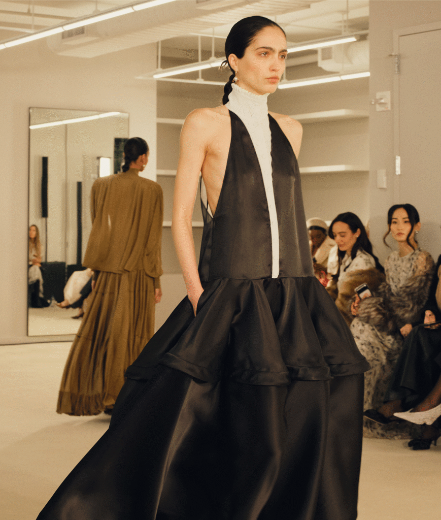 Model in a black satin halter gown with a full ruffled skirt on the Altuzarra runway