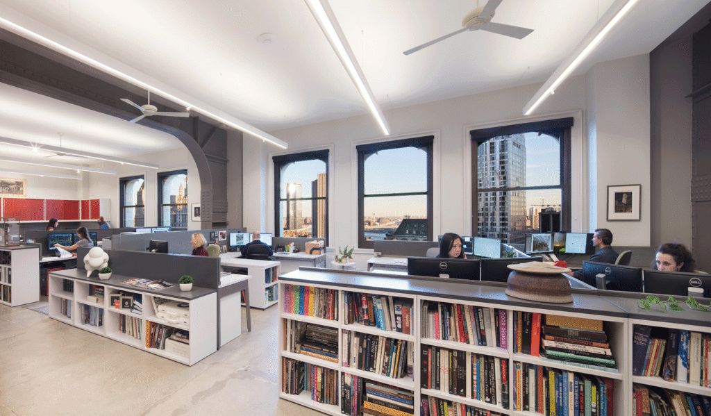 TPD Architecture's open studio with staff at desks, arched windows and shelves of material samples